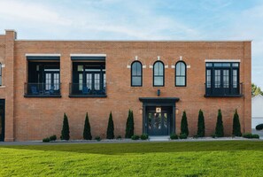 Un edificio moderno de ladrillo con fachada simétrica, ventanas amplias y una entrada central.