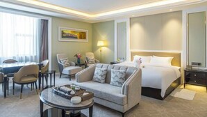 Una camera d'albergo con un letto, un divano, un tavolo da pranzo e una sedia.