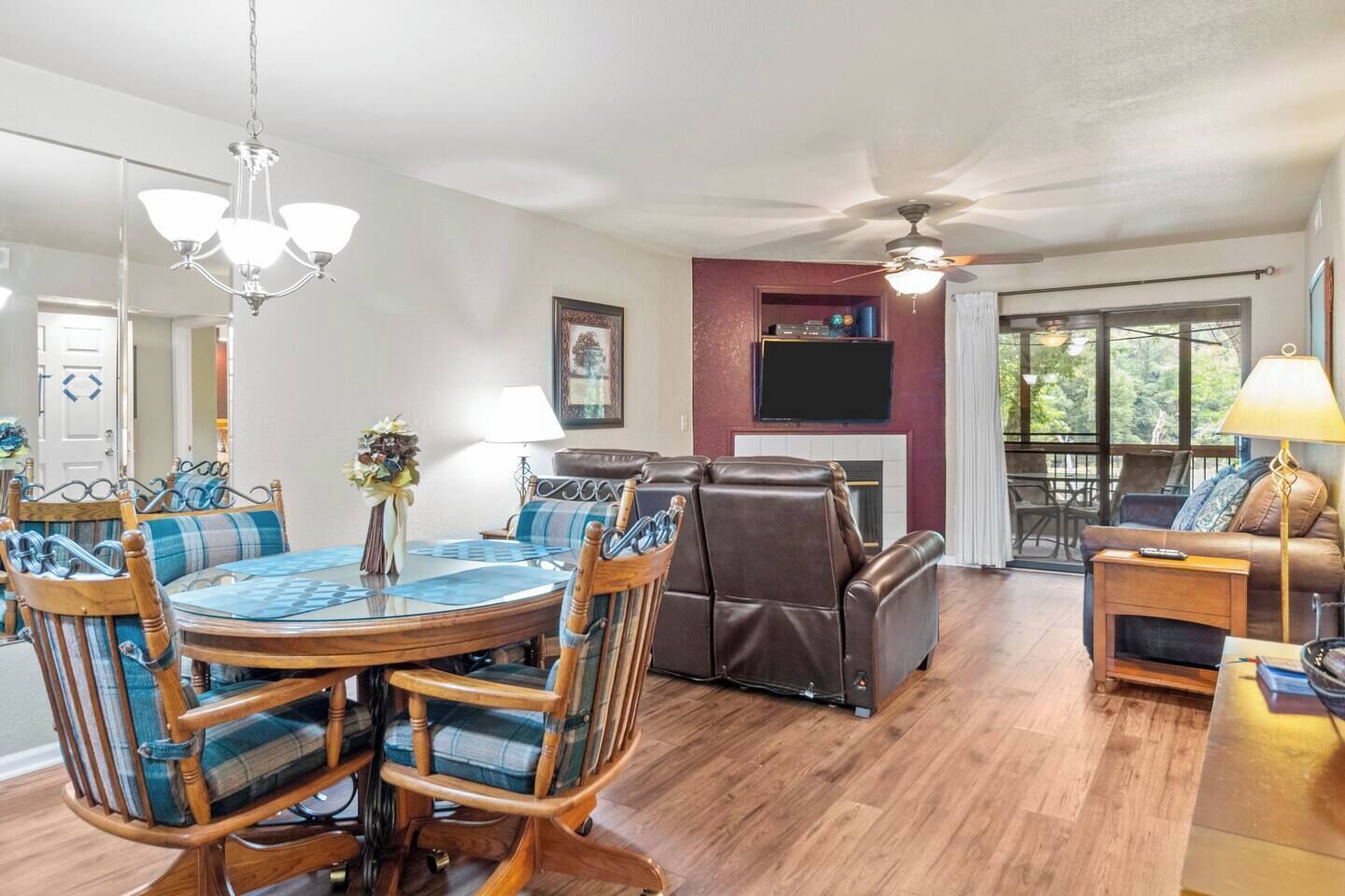 A spacious living area with a dining table, chairs, a fireplace, and a television.