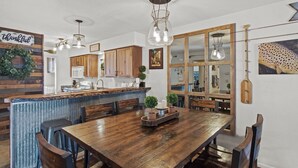 Una cocina amplia con armarios de madera, una isla grande y un comedor con mesa y sillas de madera.