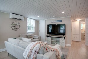 A living room with a sofa, TV, and a white cabinet. - Two Unit Duplex-2m Beach Walk (Hilton Head Island)