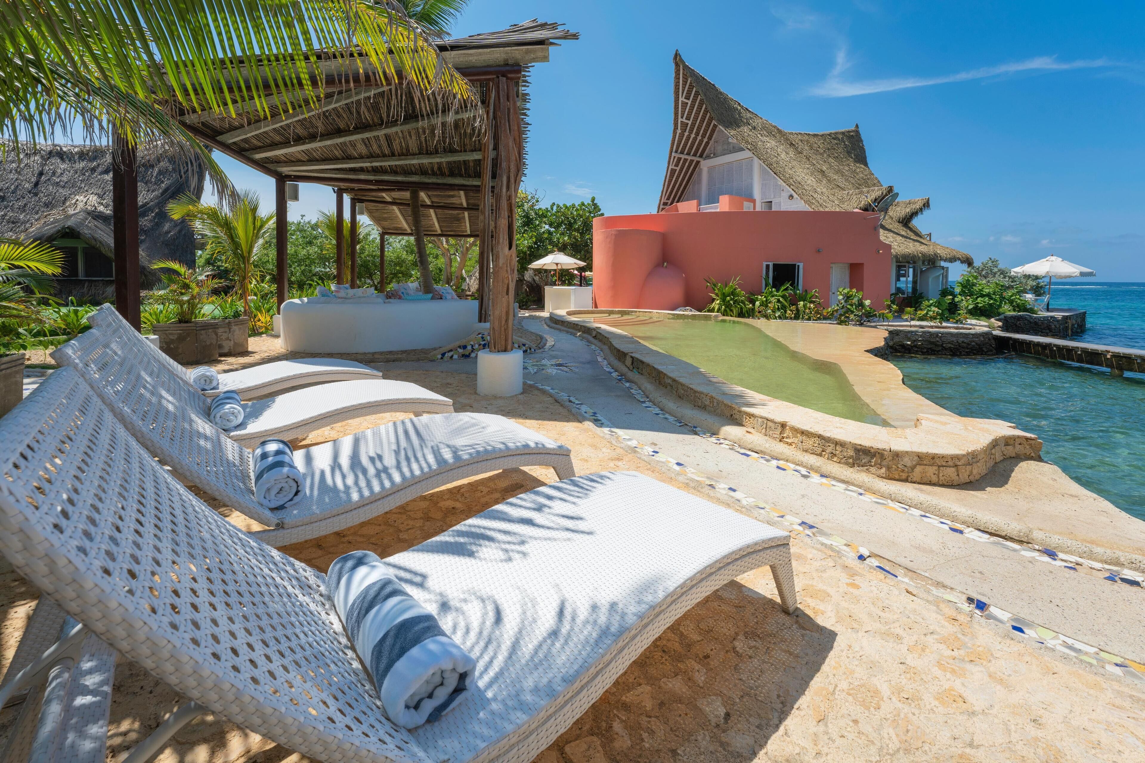 Una piscina al aire libre, sillones reclinables de piscina