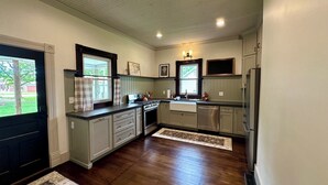 A kitchen with a central island, built-in appliances, and a view of the outdoors. - 1910 on Route 66 is a Charming historic 2 bedroom 2 bath home, close to downtown (Saint James)