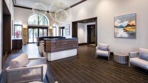 A modern lobby with a reception desk, seating area, and artwork on the walls. - Oversized 2BR Condo @ Resort near Beach (Naples)