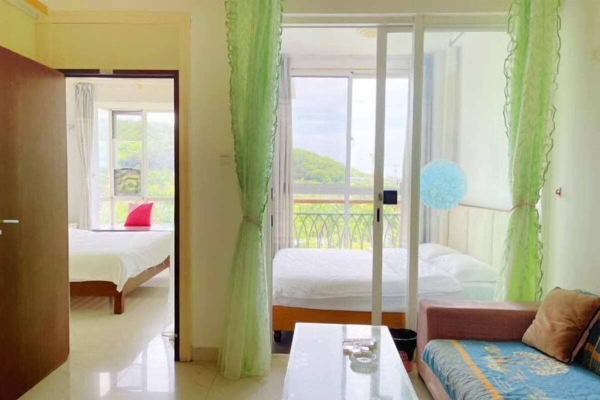 Une chambre d’hôtel avec un lit, un canapé, une table et un balcon offrant une vue.