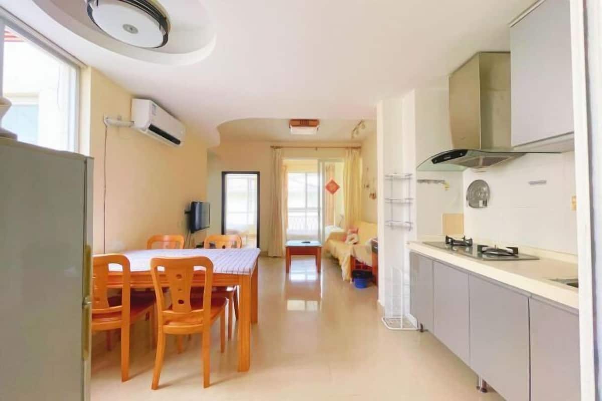 Un espace de vie compact comprenant un coin repas, une kitchenette et un canapé à l’arrière-plan.