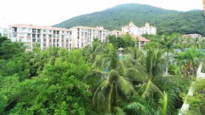 A hotel complex with multiple buildings, surrounded by lush greenery and palm trees. - Youjia Holiday Apartment Sanya Yalongwan Shenya Feicuigu (Sanya)