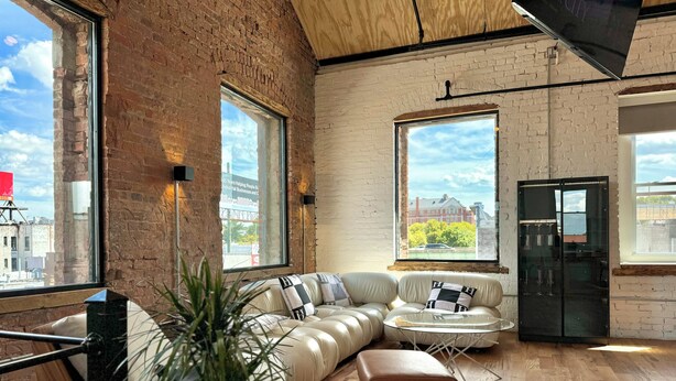 Un salon moderne avec un canapé en cuir, une table basse en verre et une plante en pot.