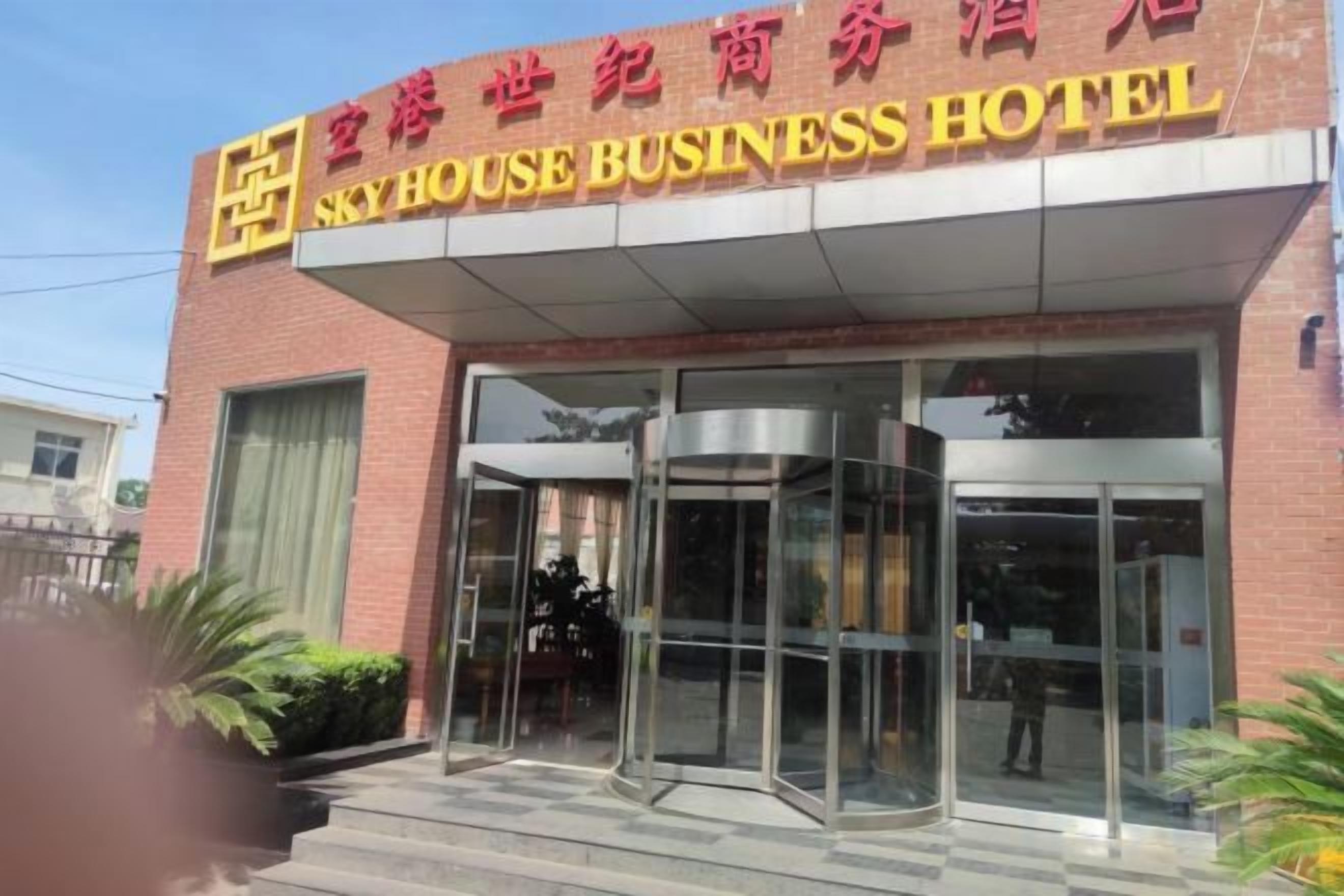 A hotel entrance with a revolving door and a sign above it.