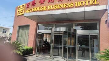 A hotel entrance with a revolving door and a sign above it.