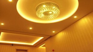 A modern interior with a circular ceiling light fixture and recessed lighting.