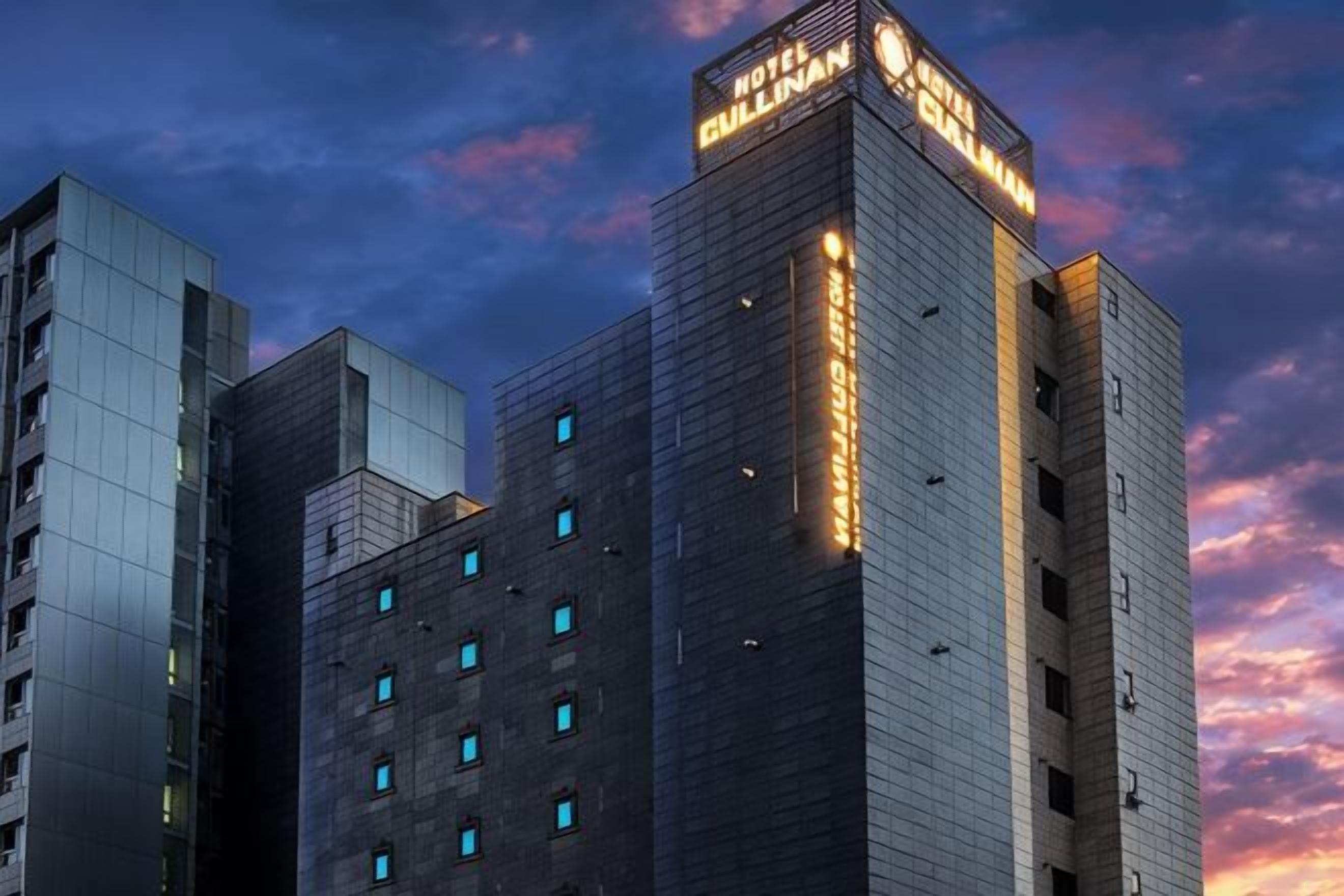 Un hôtel à plusieurs étages, doté d’une enseigne bien visible au sommet et présentant un design architectural moderne.