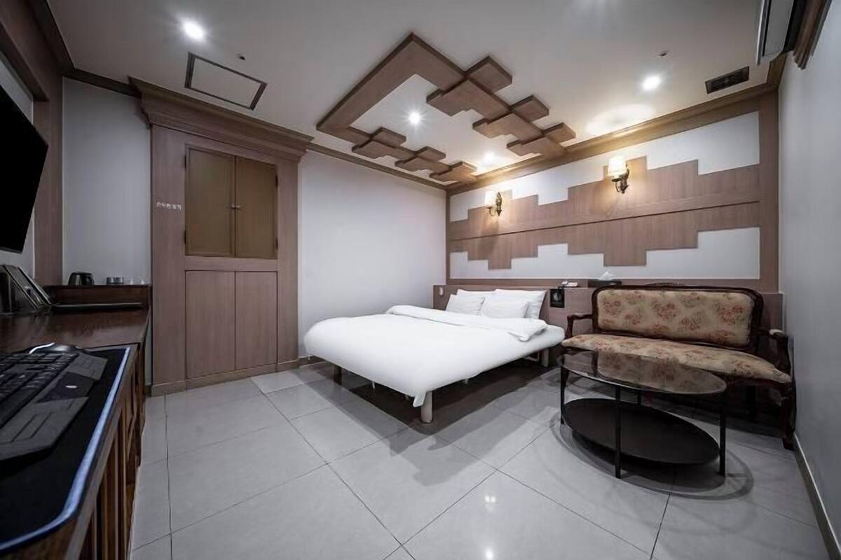 Une chambre à coucher moderne avec un lit, un bureau, une chaise et un canapé.