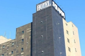 Un edifici d'hotel modern amb un distintiu rètol que diu "HOTEL" a la part superior.