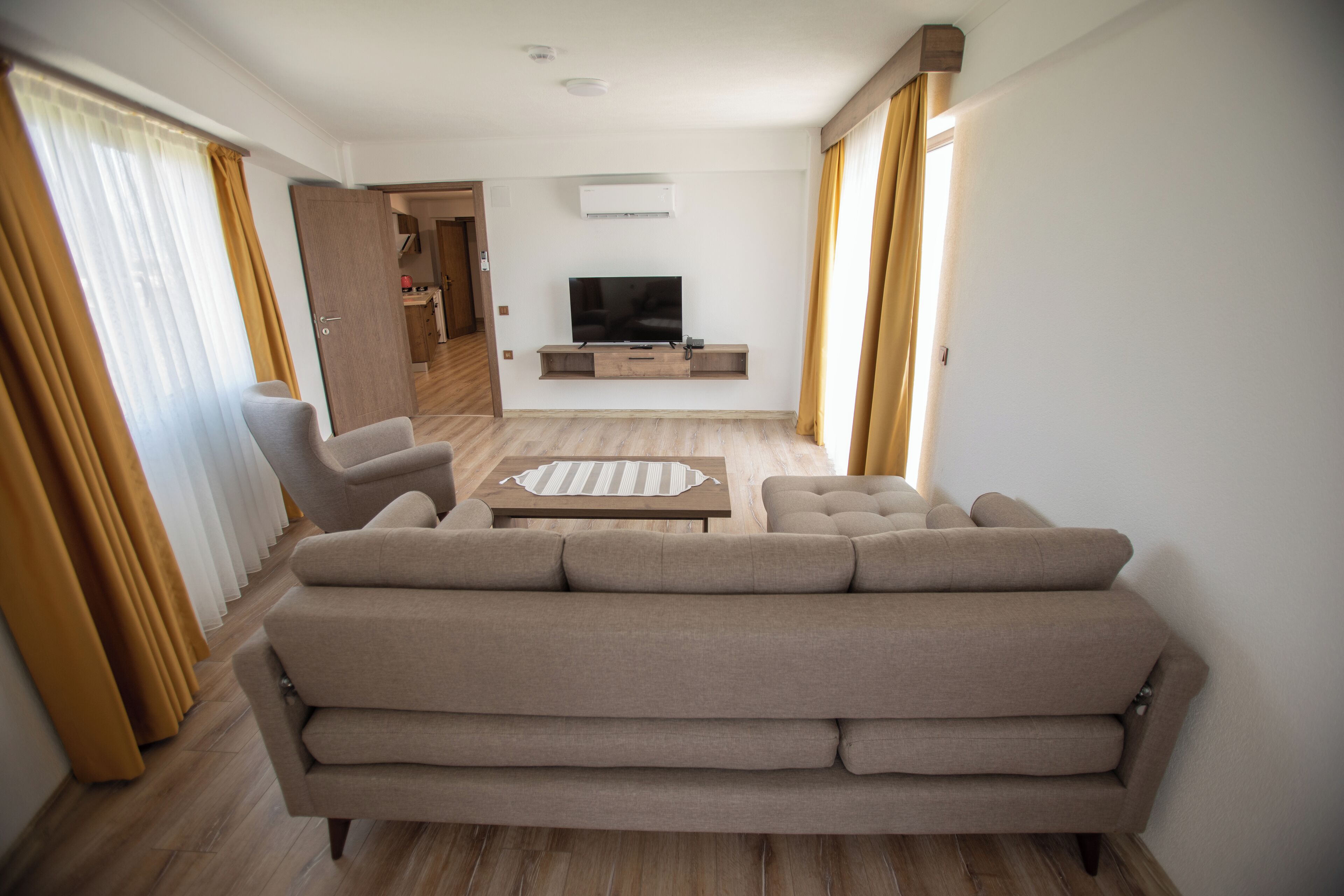 A modern living room with a sofa, a coffee table, and a TV.