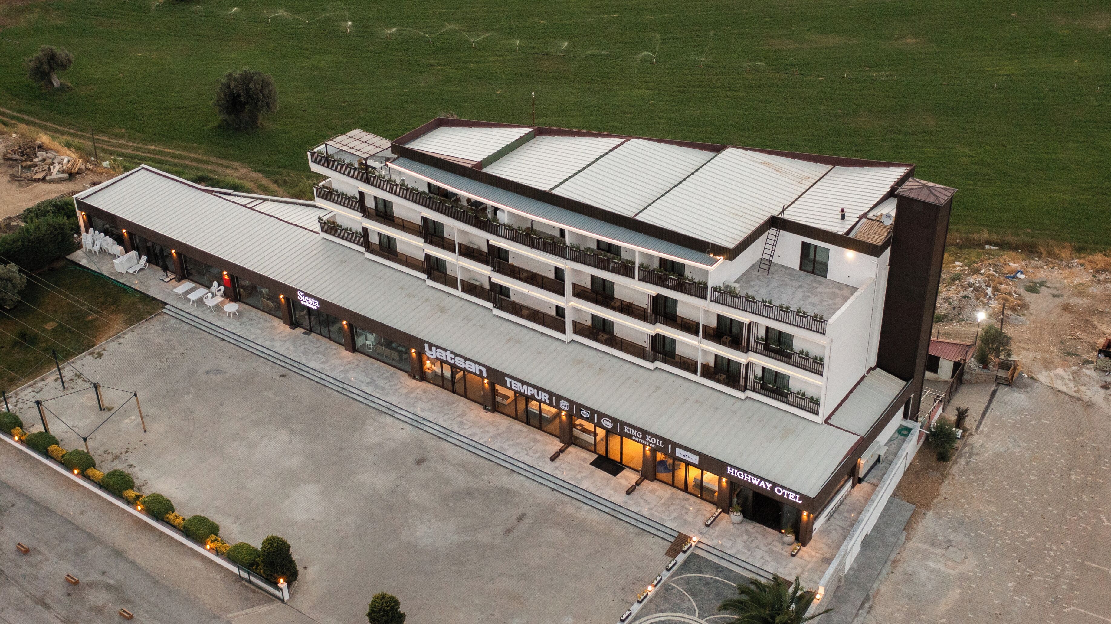 A multi-story hotel with a flat roof, multiple balconies, and a ground-level restaurant.