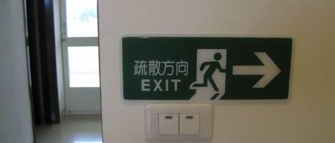 An exit sign with a directional arrow and a pictogram of a person running.