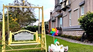 Un columpio con una cisne y un molinete en una zona con césped.