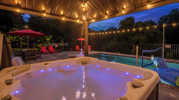 A hot tub with LED lights, surrounded by outdoor seating and string lights. - "Final Frontier"- Pool, Hot Tub, Pickleball, Basketball, Pond, Arcade, Putt Putt (Troutman)
