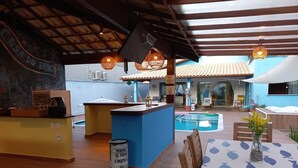 A poolside area with a bar, seating, and a sign indicating a menu. - Big house with 4 bedrooms, 4 1/2 bath, barbecue area,. Pool, Jacuzzi and parking (Arraial d'Ajuda)
