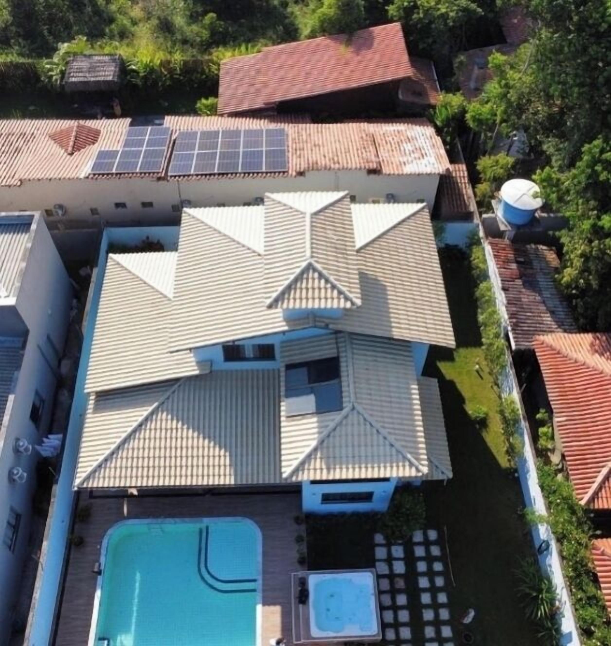 Ein Wohngebäude mit Schwimmbad, Solaranlage und Garten.