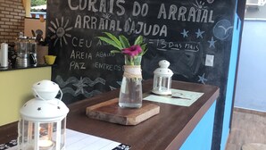 A reception desk with a chalkboard displaying a welcome message, a vase with a flower, and two lanterns. - Big house with 4 bedrooms, 4 1/2 bath, barbecue area,. Pool, Jacuzzi and parking (Arraial d'Ajuda)