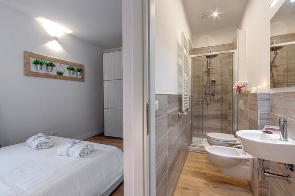 Appartement | Badkamer | Een douche, een haardroger, een bidet, handdoeken