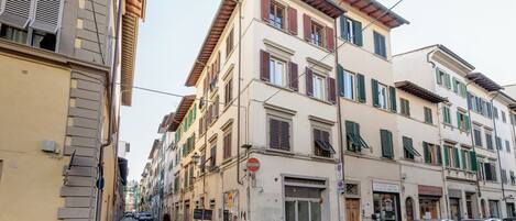 Une rue bordée d’immeubles, avec un panneau indiquant l’interdiction de circuler et des voitures garées.