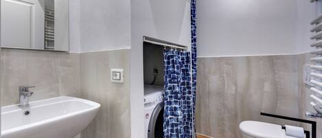 Ein modernes Badezimmer mit Waschbecken, Toilette und Waschmaschine.