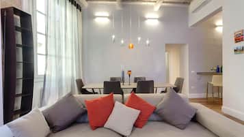 Una sala de estar moderna con un sofá, una mesa de comedor y una estantería.