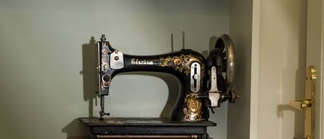 A vintage sewing machine on a wooden base in a room with a white door and light-colored walls.
