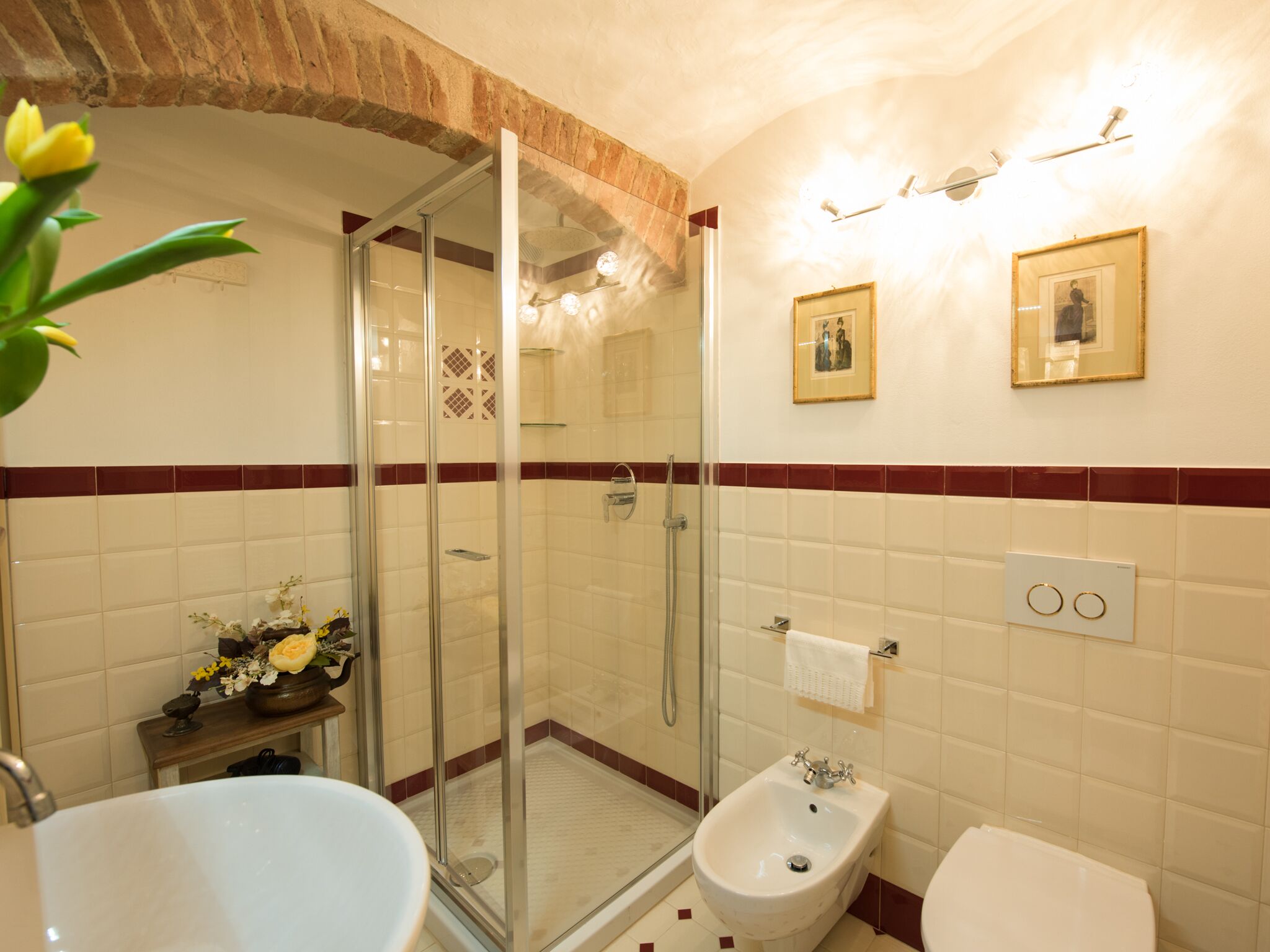 A bathroom with a glass-enclosed shower, a bidet, and a sink.