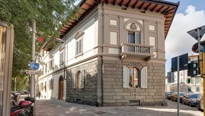 Edificio histórico con balcón, fachada de piedra y un cartel que indica una ruta ciclista.