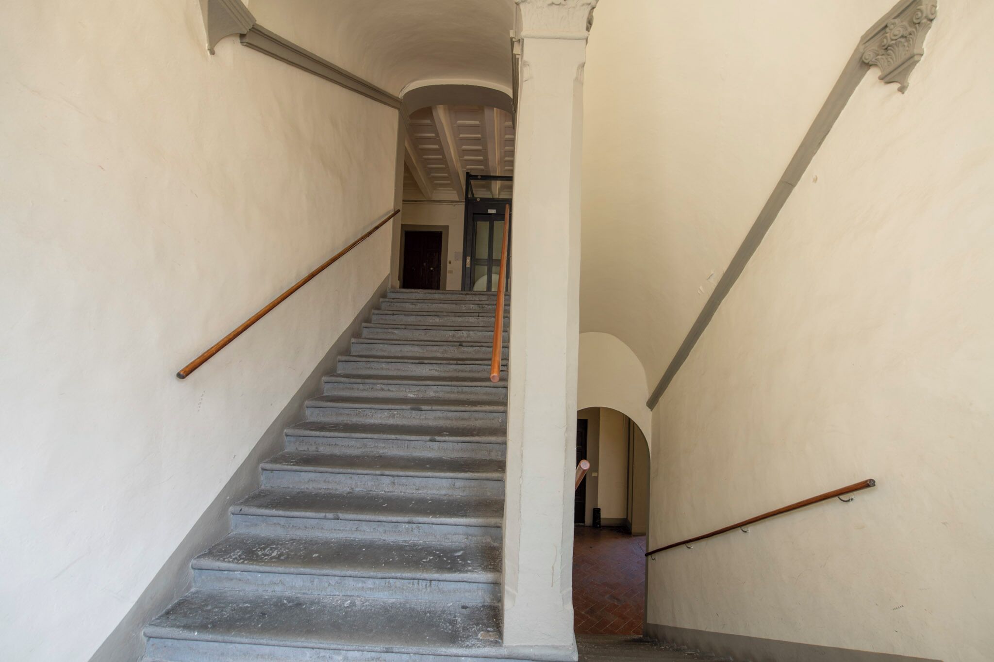 A staircase with a handrail, leading to a door at the top.