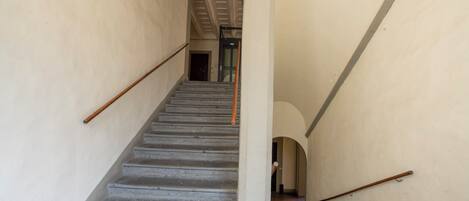 A staircase with a handrail, leading to a door at the top.