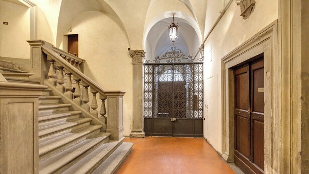 A grand staircase leading to a door with intricate ironwork. - Mamo Florence - Casper Apartment (Florence)