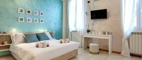 Un dormitorio con cama, mesita de noche y televisor montado en la pared.