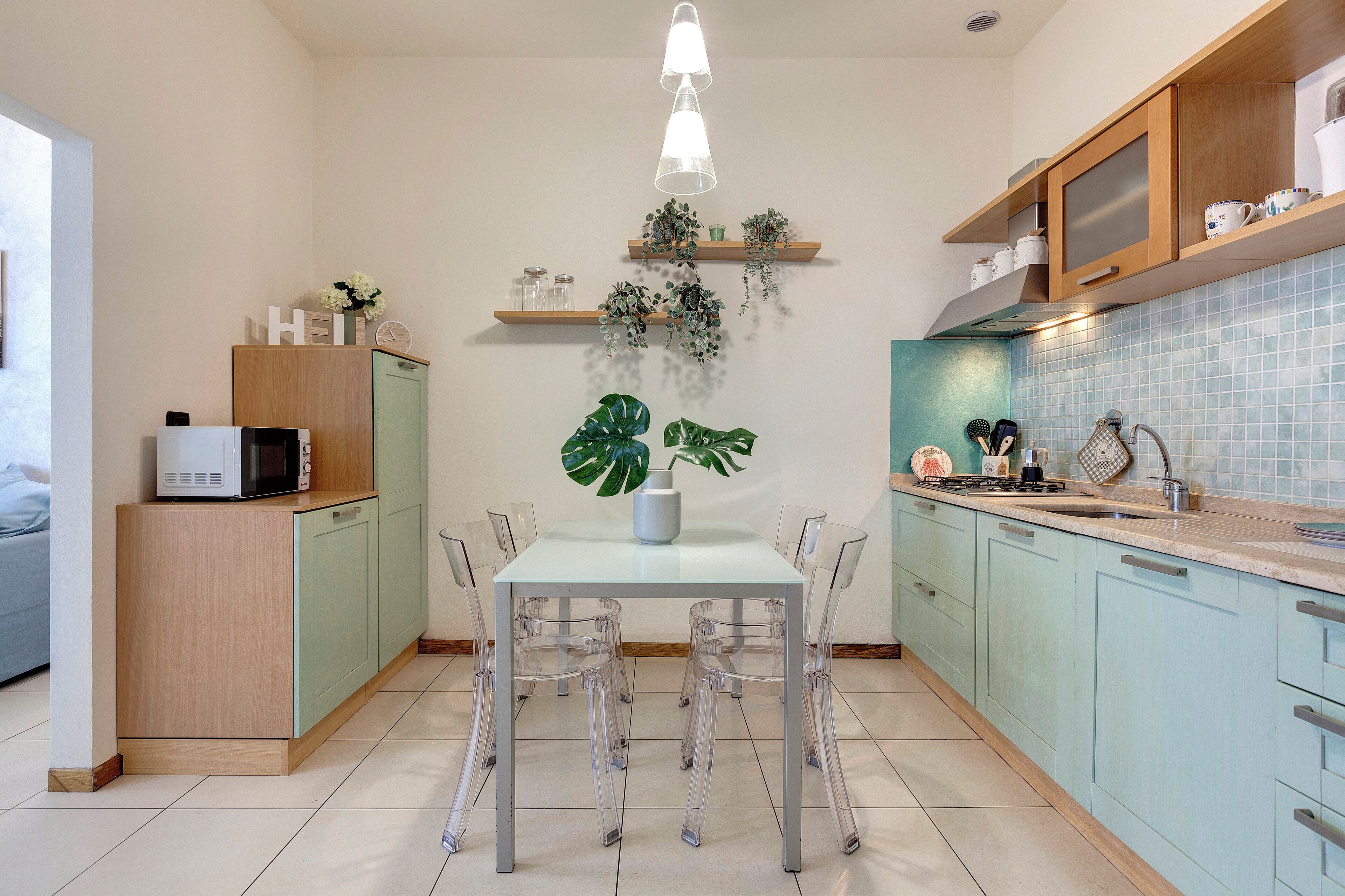 Uma cozinha moderna com uma mesa de jantar, cadeiras e um micro-ondas sobre um armário.