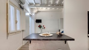 A modern kitchen with a dark countertop, a red bowl, and a white chair. - Mamo Florence - Cristofano Studio (Florence)
