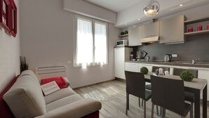 A modern apartment with a dining area, kitchen, and a living room with a sofa and a red pillow. - Mamo Florence - Dante & Virgilio Apartments (Florence)