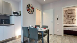 A compact living space with a kitchenette, dining area, and a bedroom. - Mamo Florence - Dante & Virgilio Apartments (Florence)