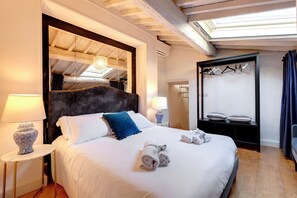 Een hotelkamer met een groot bed, twee bedlampjes, een spiegel, een kledingkast en een hangroede.