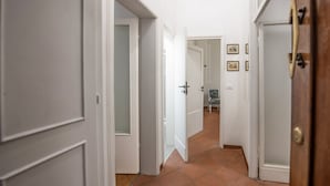 A hallway with white doors and a tiled floor. - Mamo Florence - Macci Apartment (Florence)