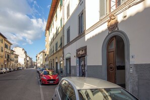 Une rue bordée de voitures garées et d’immeubles, dont un bar et un restaurant.