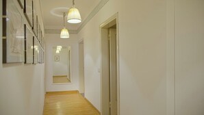 A hallway with wooden flooring, white walls, and a door on the right. - Mamo Florence - Palazzo Spinelli Apartment (Florence)