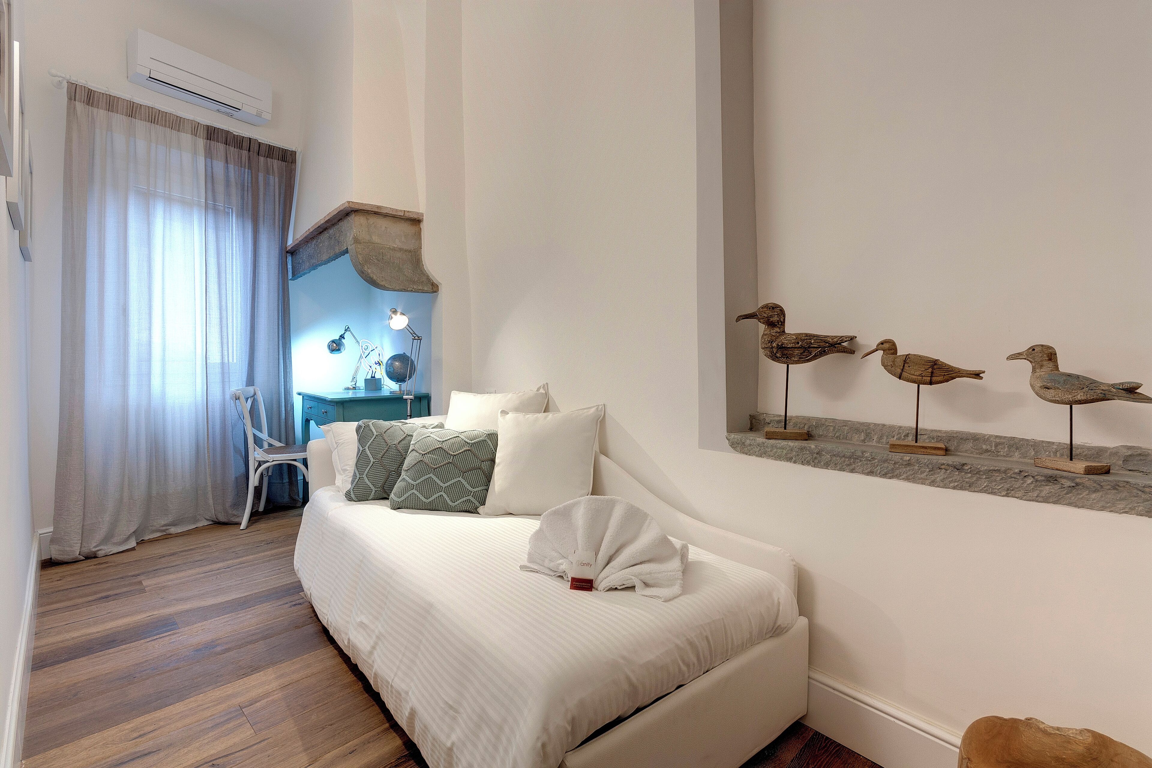 Een hotelkamer met een bed, bureau, stoel en wanddecoratie.