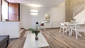 Ein moderner Wohnbereich mit Essplatz, Küche und Treppe.
