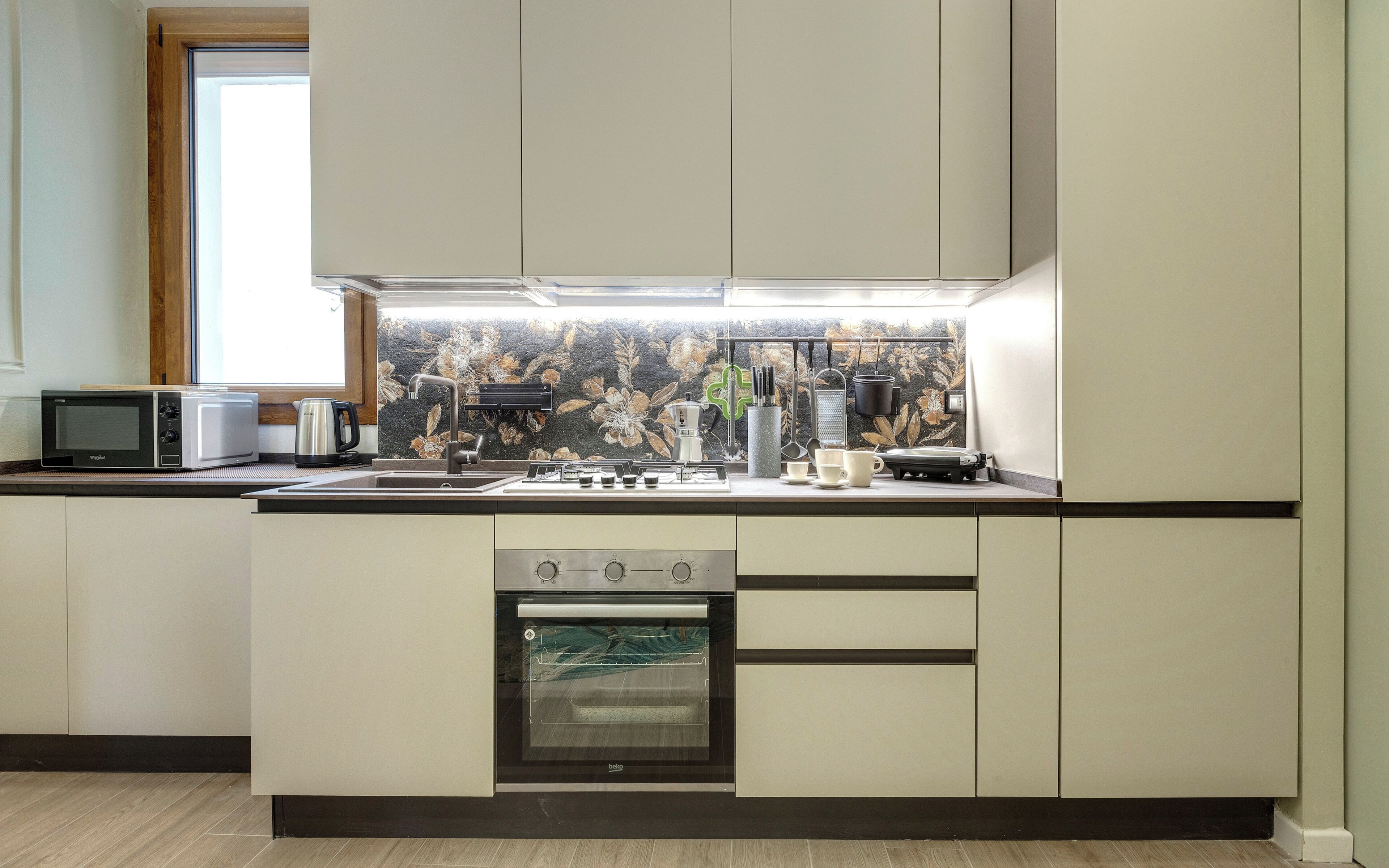 A modern kitchen with a built-in oven, a microwave, and a coffee maker.