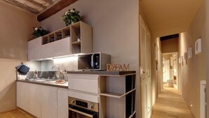 Une cuisine moderne dotée d’appareils électroménagers intégrés, d’un plancher en bois et d’un couloir menant aux autres pièces.