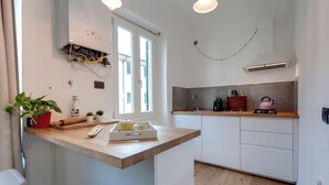 Eine kleine Küche mit Holzarbeitsplatte, integriertem Herd und einem Fenster für natürliches Licht.